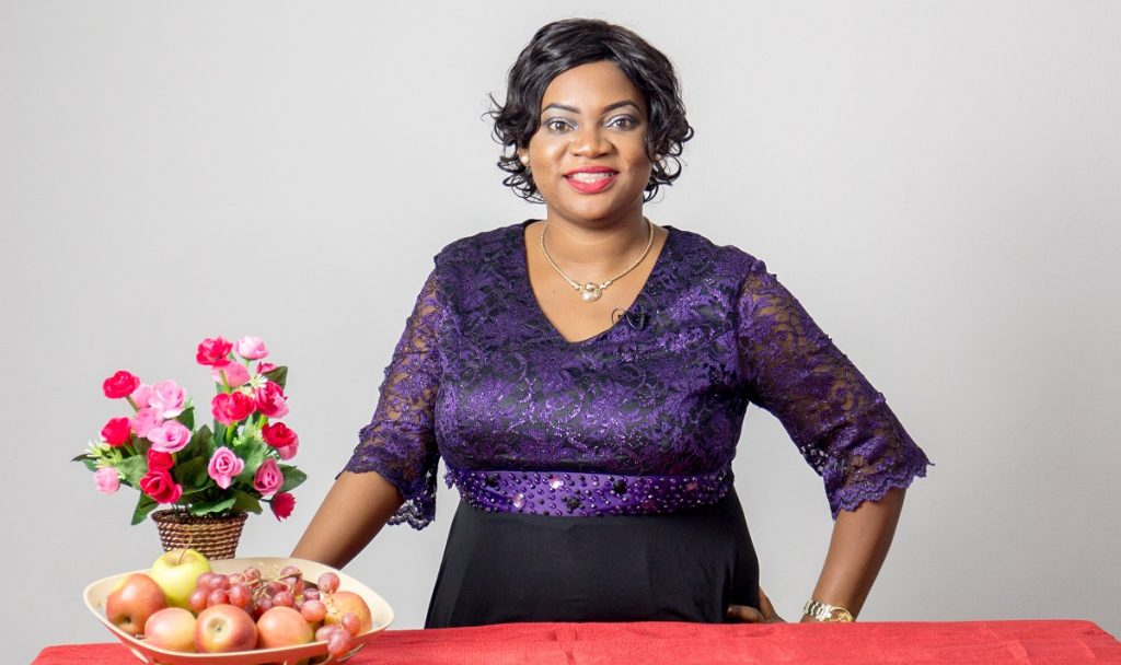 Ronke Taiwo standing in front of a table
